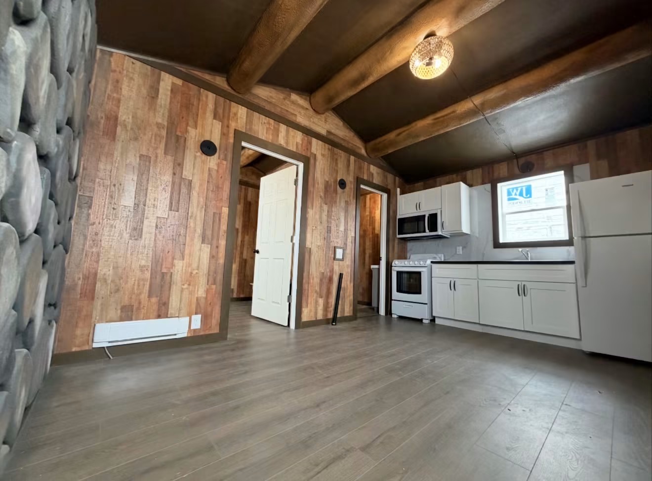 Infinity Capsule interior with timber beams, wood plank walls and full kitchen with appliances